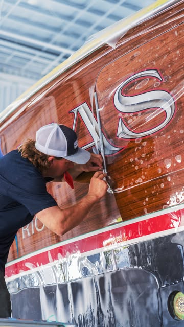 Hand-finishing transom lettering and brightwork on a classic hull